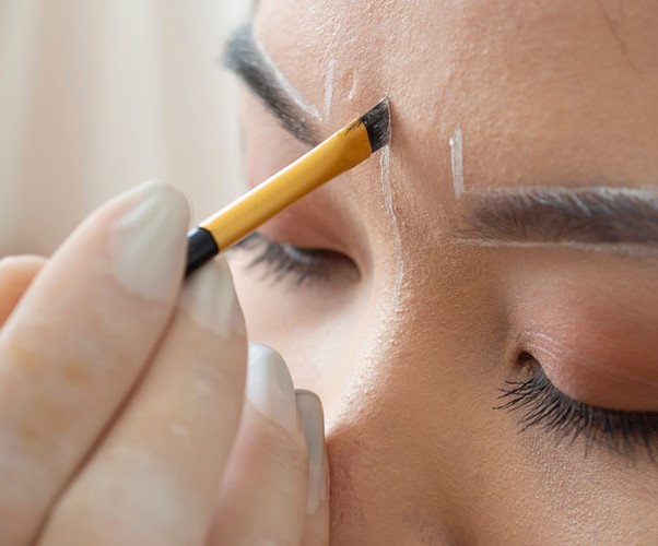 Close-up of powder brows application process on a woman's eyebrows