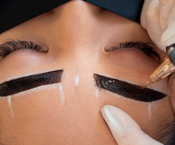 Young woman undergoing a microblading procedure on her eyebrows